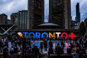 Vibrant evening at Toronto City Hall with festive crowd enjoying the cityscape.